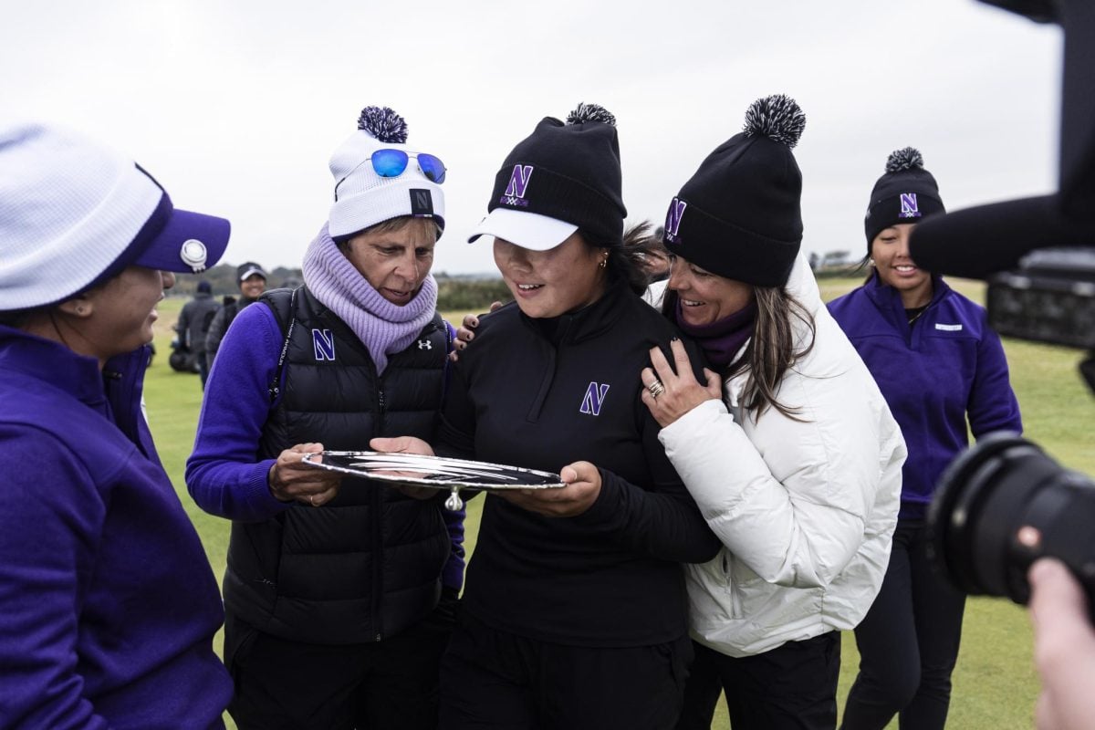 Northwestern golfer Ashley Yun celebrates winning the individual competition at the St Andrews Links Collegiate with coaches and teammates.