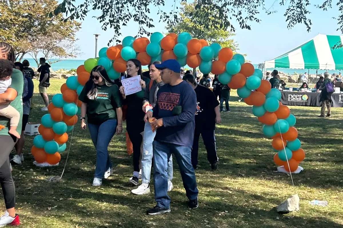 Attendees walk through a balloon arch to begin the one-mile walk at PEER Services’ Step Up for Recovery event Sunday.
