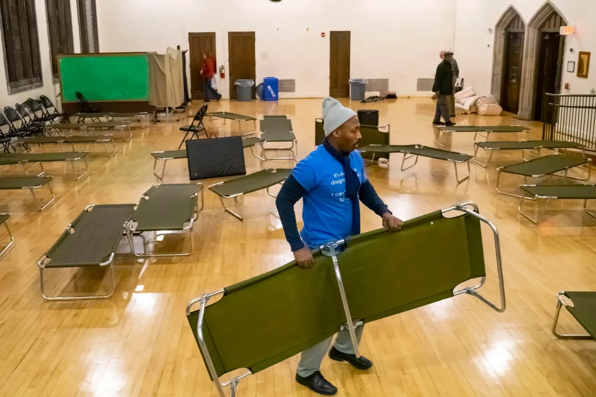  Interfaith Action of Evanston volunteers set up cots for an overnight shelter at Lake Street Church, one of the city’s faith organizations that allows its space to be used for sheltering unhoused people overnight during periodic winter months.
