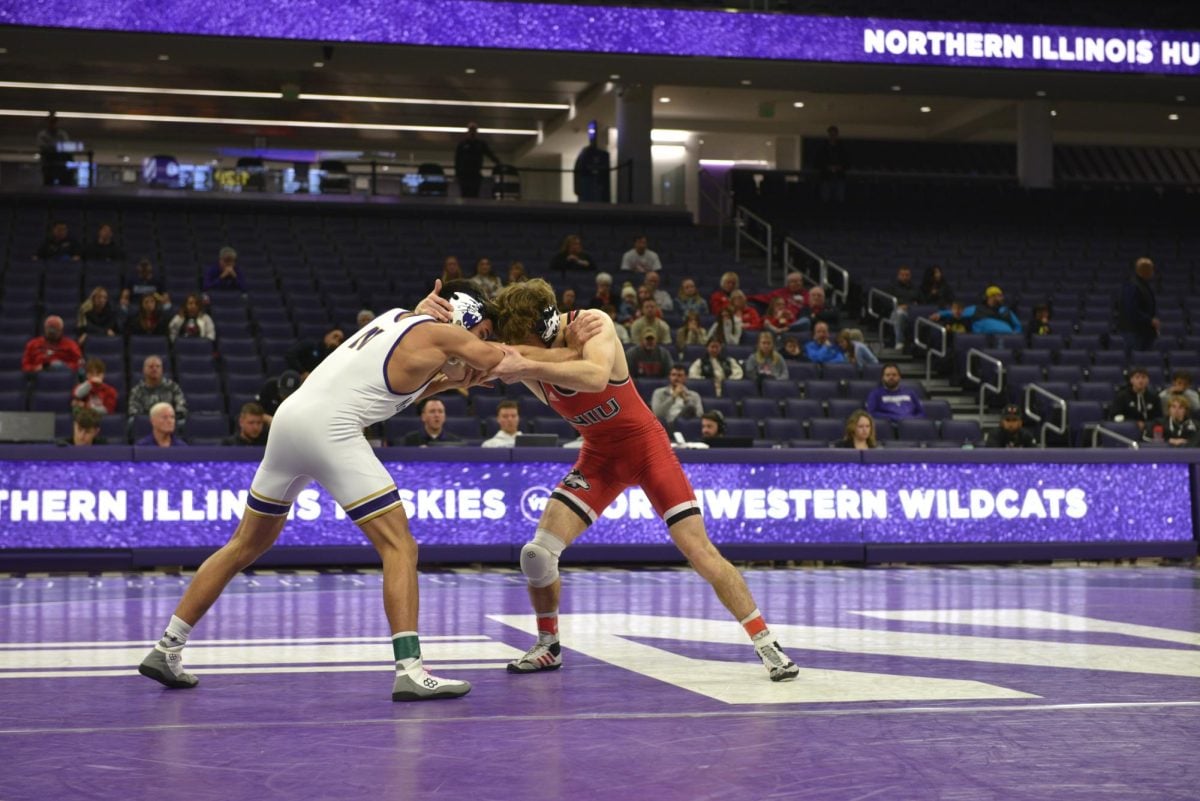 Redshirt freshman 125-pounder Dedrick Navarro tussles with No. 27 Blake West in the opening match of Northwestern’s 29-8 win over Northern Illinois Saturday.