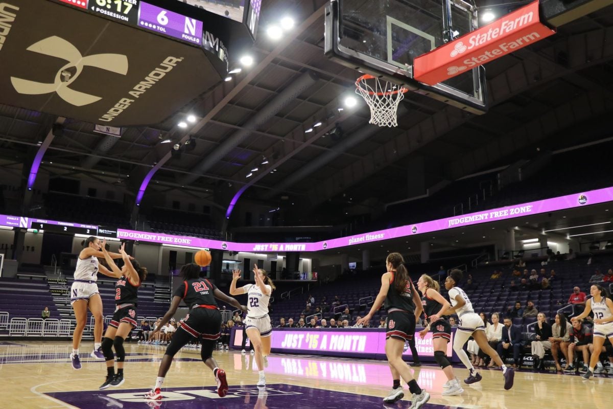 Two players pass the ball in the paint.