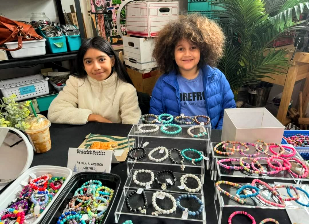 Youth vendors Paola and Arleigh sell handmade bracelets as “Bracelet Besties.” 
