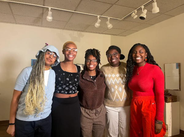 Five members of the Black Poetry Society with their arms around each other.