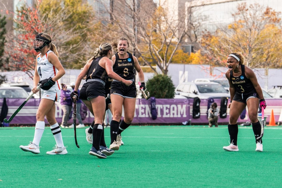 Sophomore forward Ashley Sessa, senior midfielder Maddie Zimmer and sophomore forward Olivia Bent-Cole celebrate a goal against Virginia Sunday. Northwestern won in overtime, 3-2.