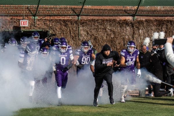 Coach David Braun leads Northwestern onto the field before its season finale against No. 23 Illinois on Saturday.