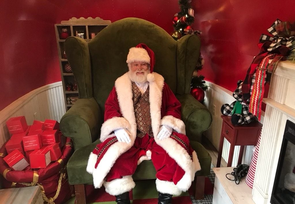 a person in a santa costume in a chair.