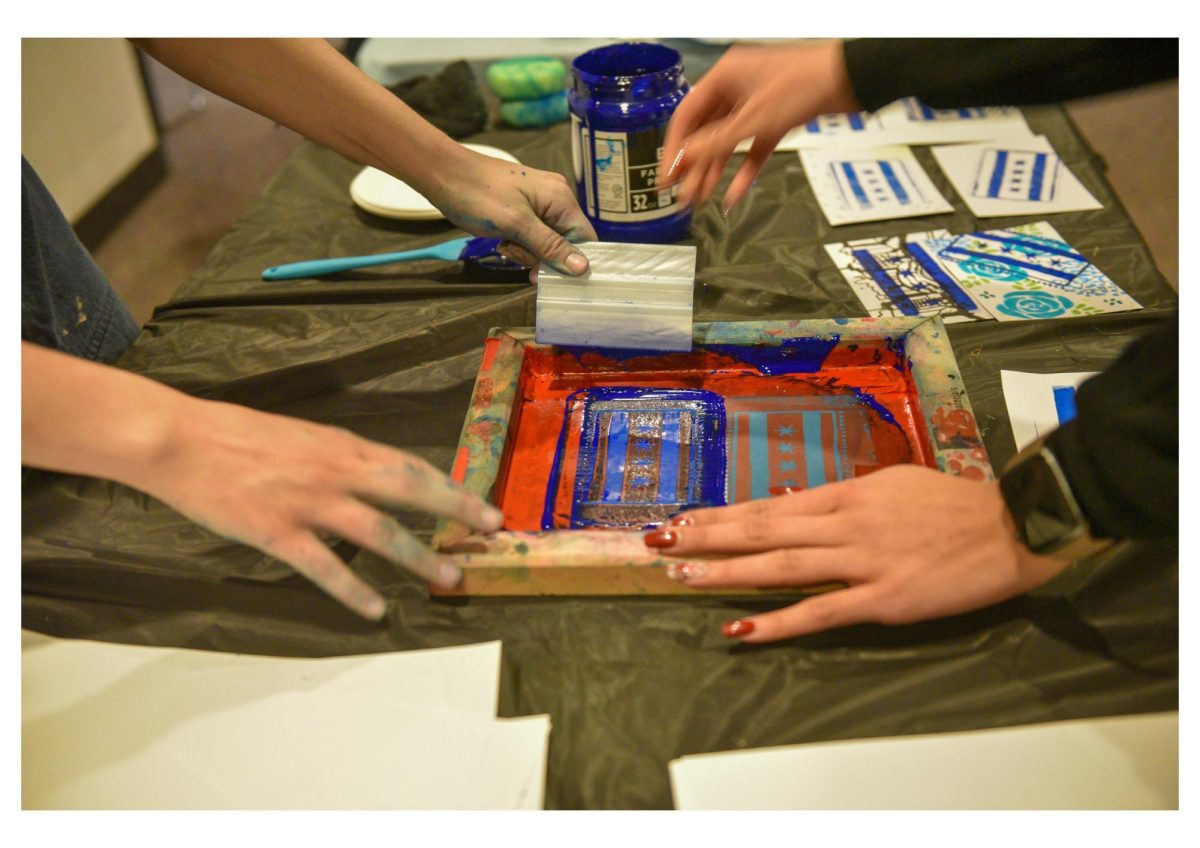 An Artica Studio worker teaches a student how to screen print.