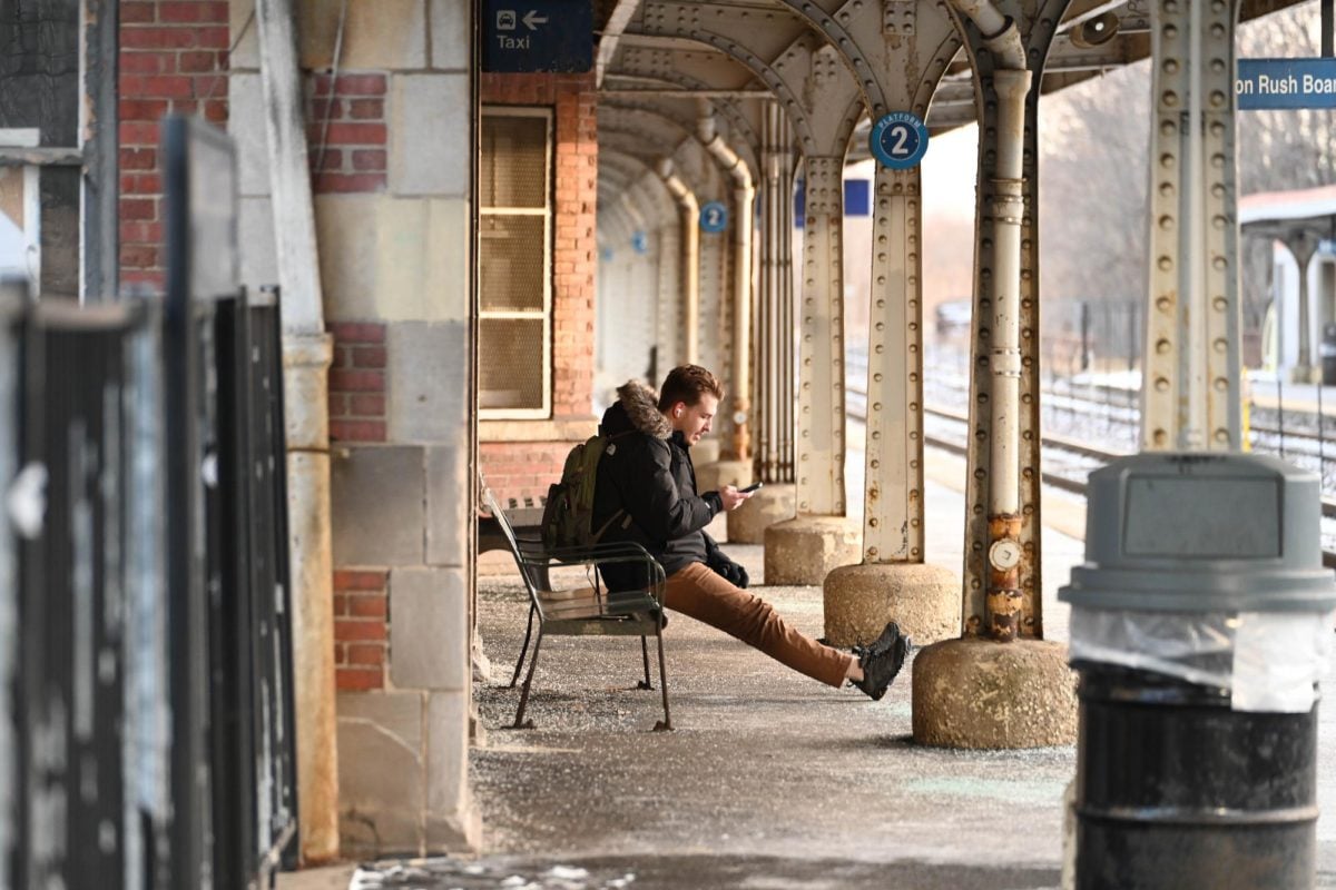 A man waits on Tuesday at the Davis Street Metra station, which the regional rail operator plans to revamp.