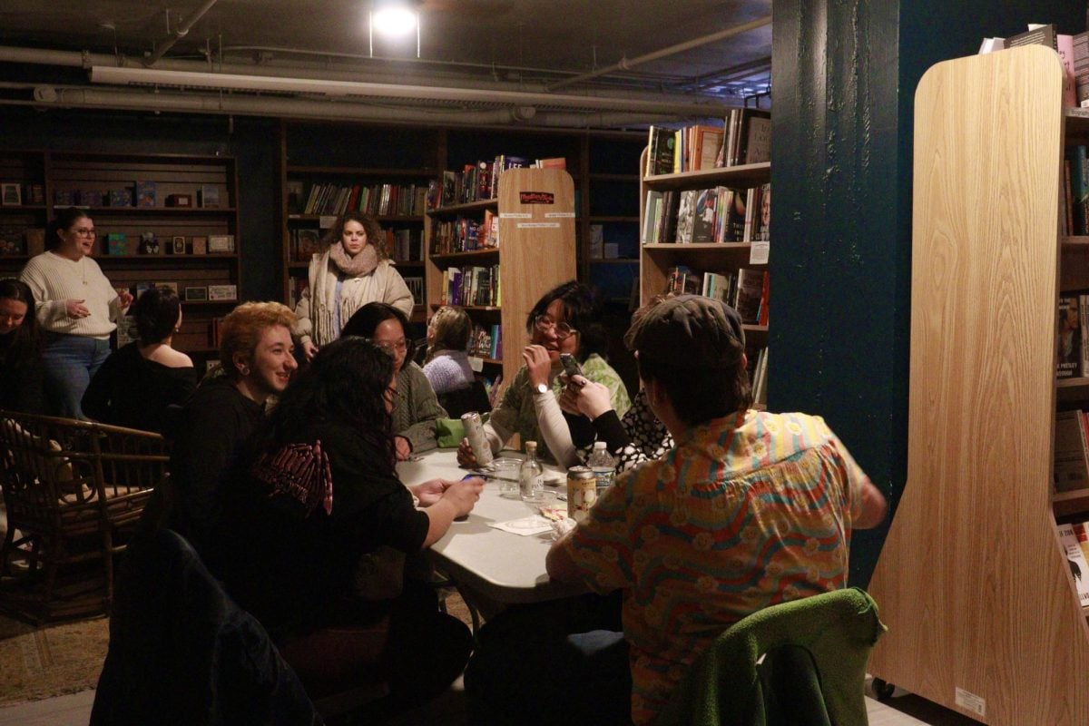 Over 10 people seated around tables, conversing and laughing.