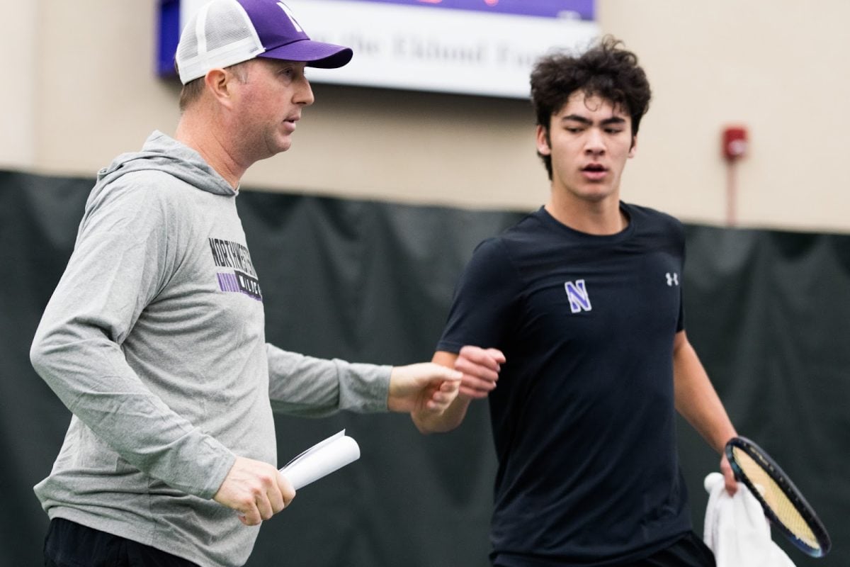 Coach Arvid Swan fist bumps sophomore Greyson Casey during a match last season.