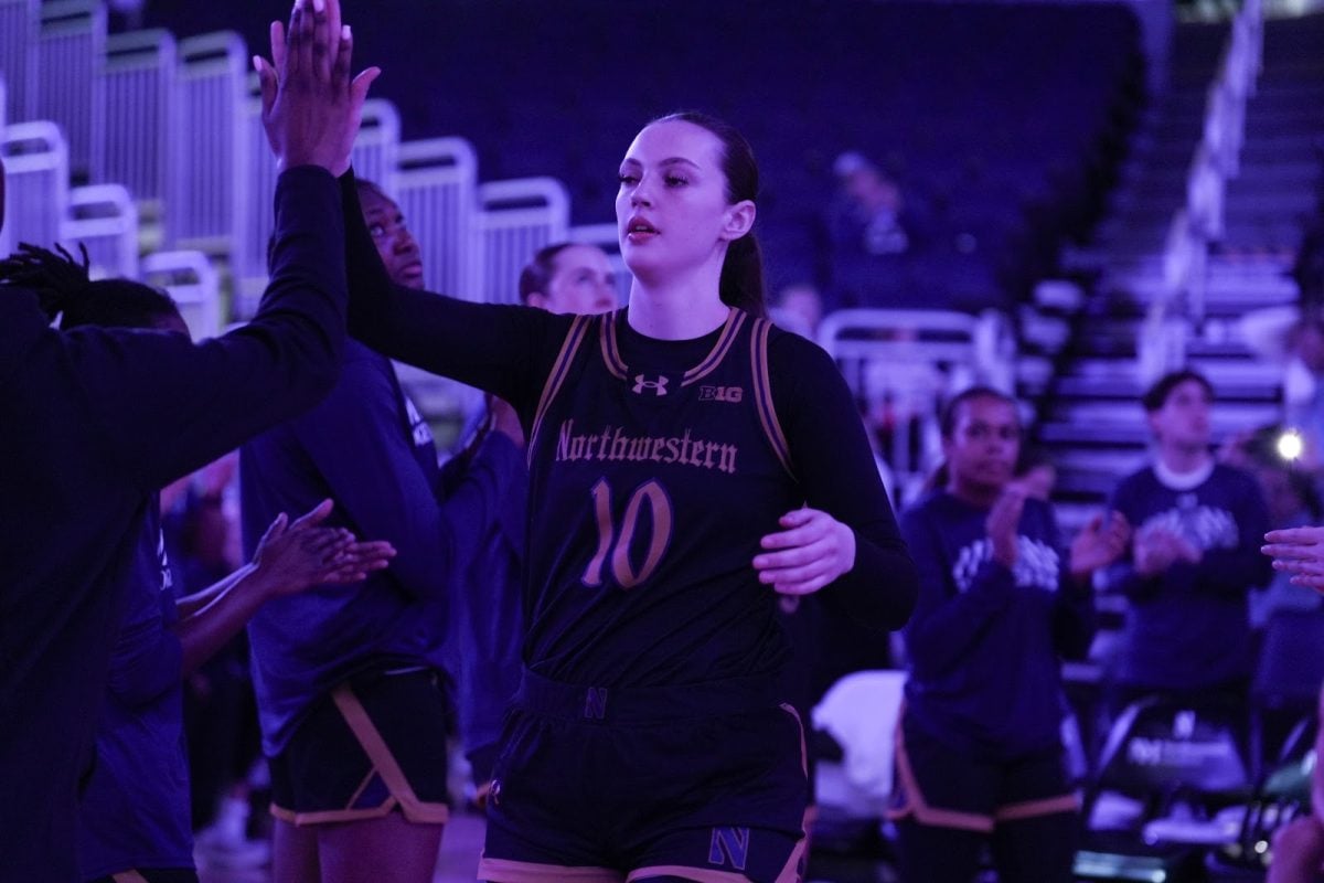 Senior forward Caileigh Walsh high fives a team member before a game earlier this season.