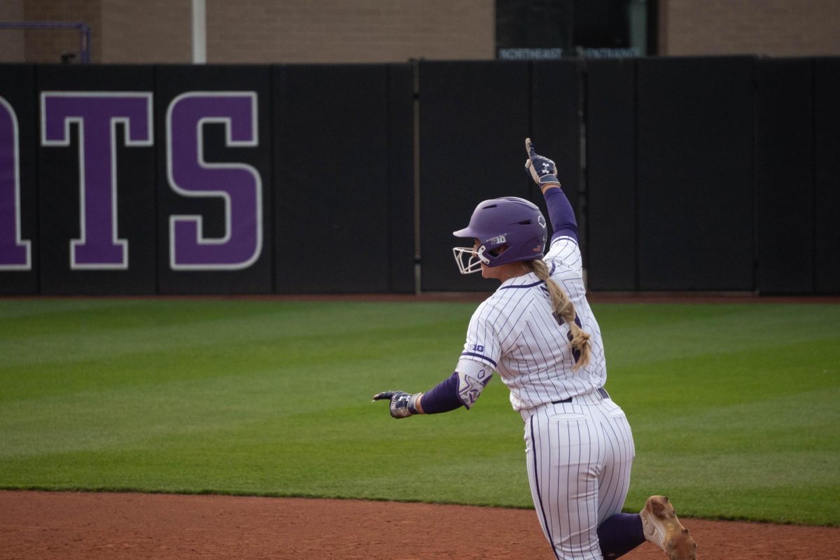 A player points as she jogs around the bases.