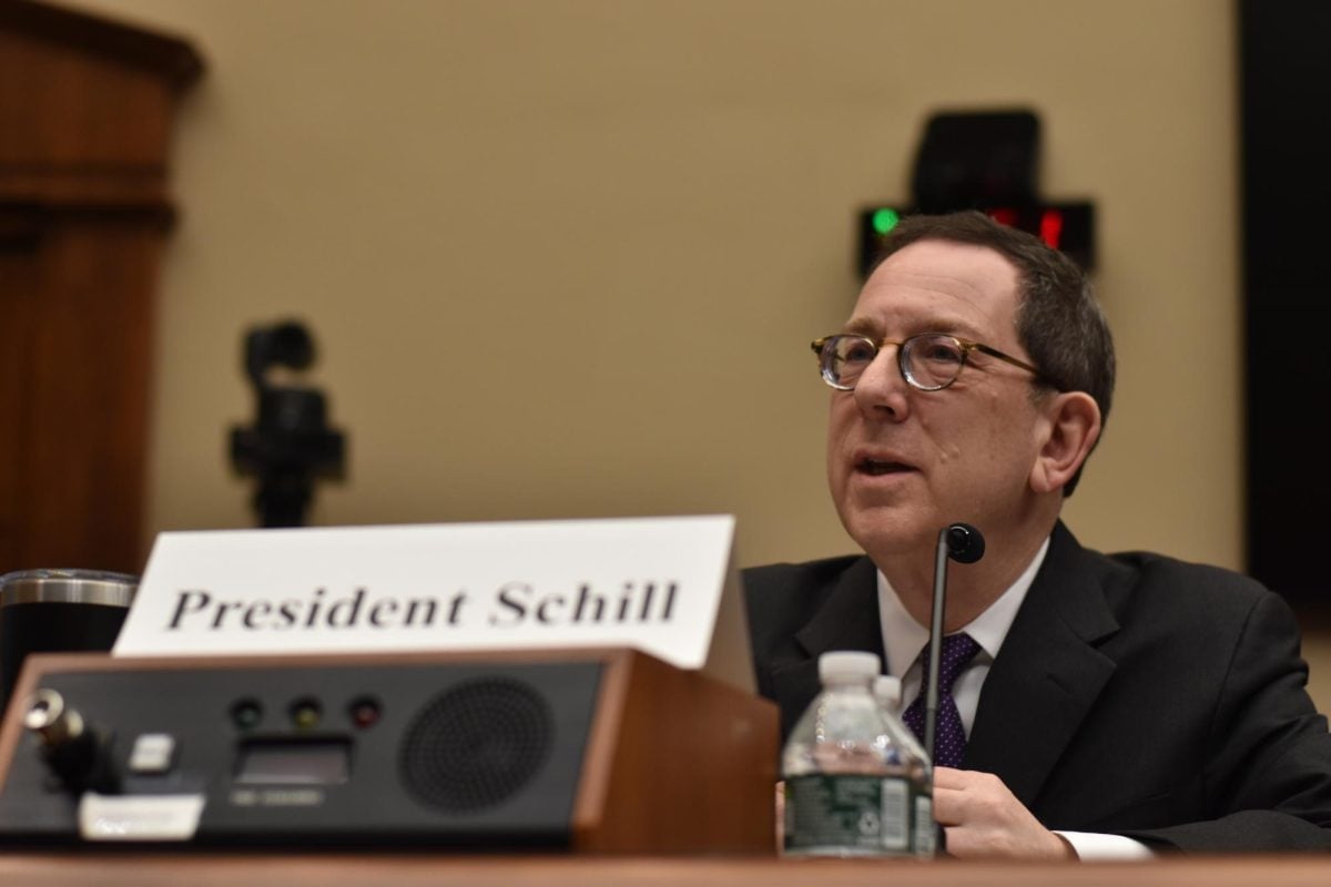 A man is talking, sitting down in front of a microphone.