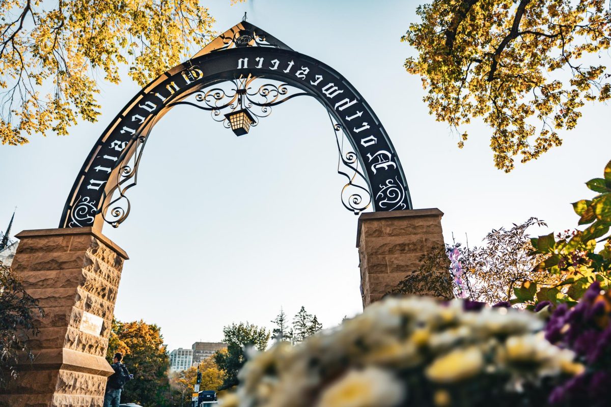 The Northwestern Arch appears amid a clear sky and greenery.