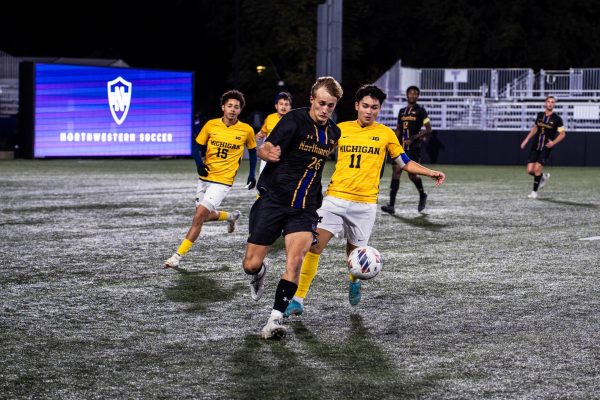 Junior defender Bryant Mayer battles a Michigan defender in a game last season.
