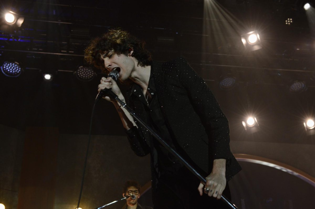 Close up of a singer tilting to the side while gripping the microphone. 