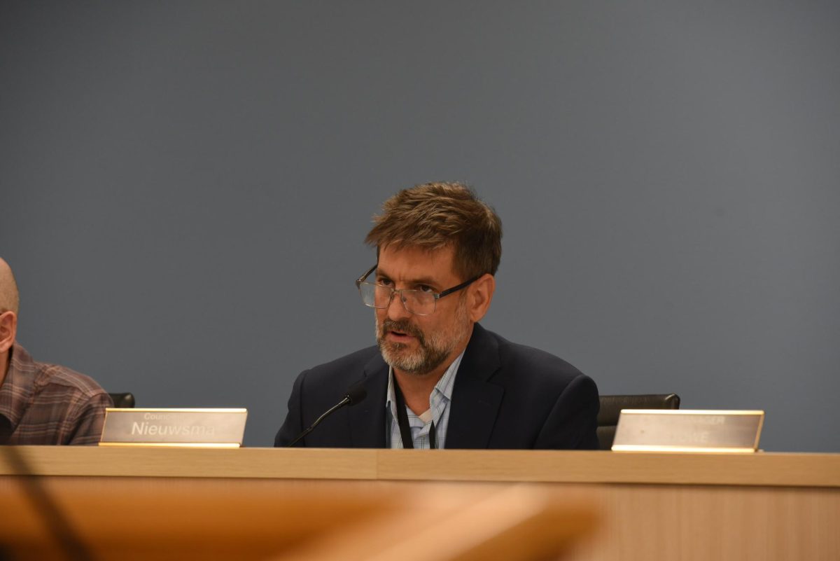 A council member sits in his chair and listens.