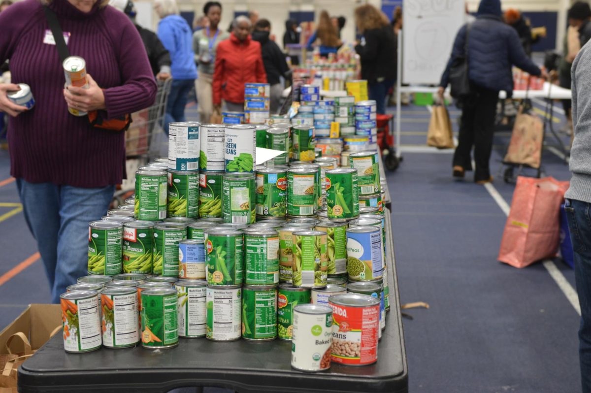 Green cans of vegetables sit on a folding table.