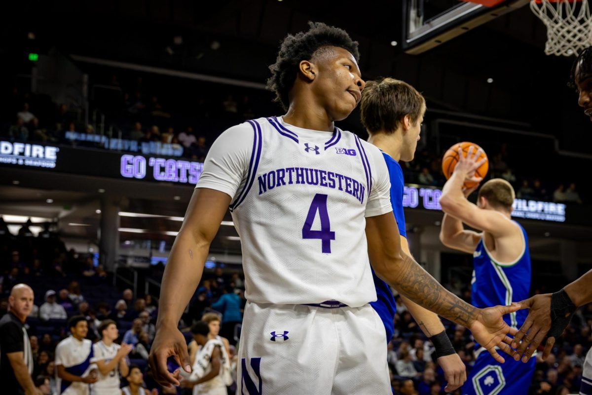 A player in a white jersey turns to look at his teammate after getting fouled.