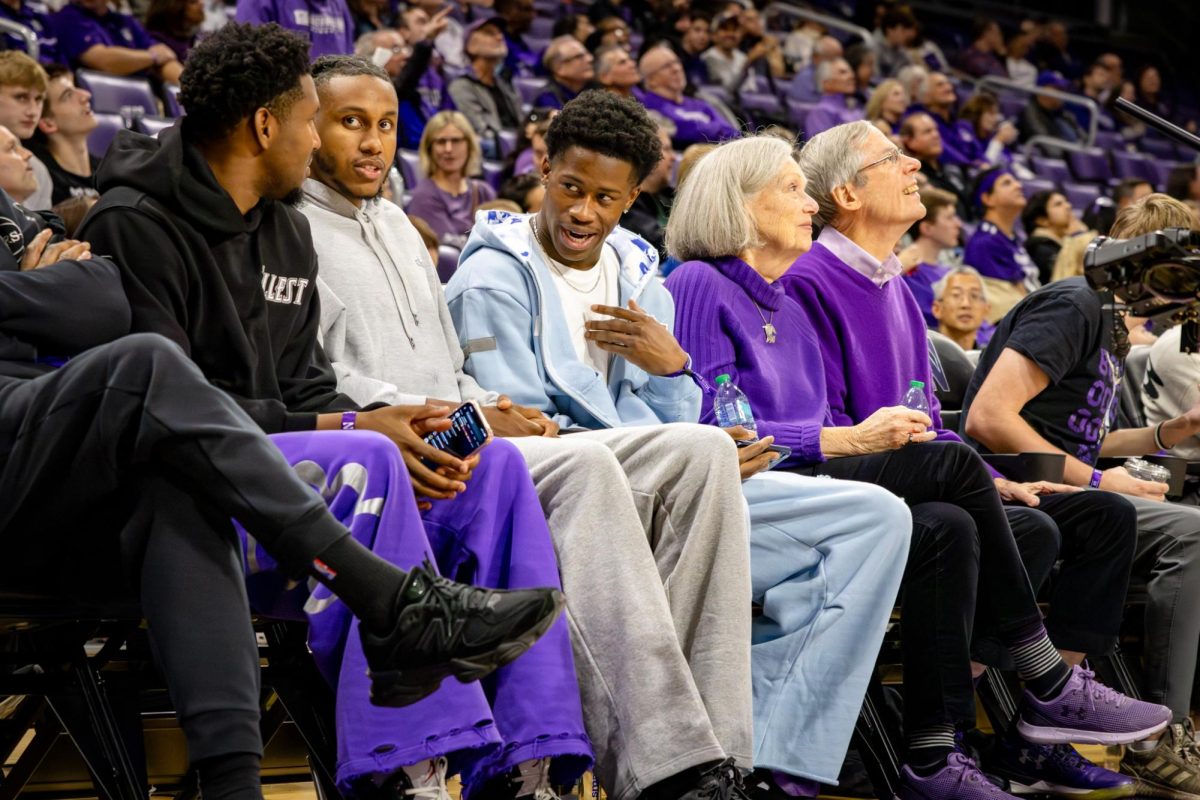 Philadelphia 76ers players talk amongst themselves while watching the game from the front row.