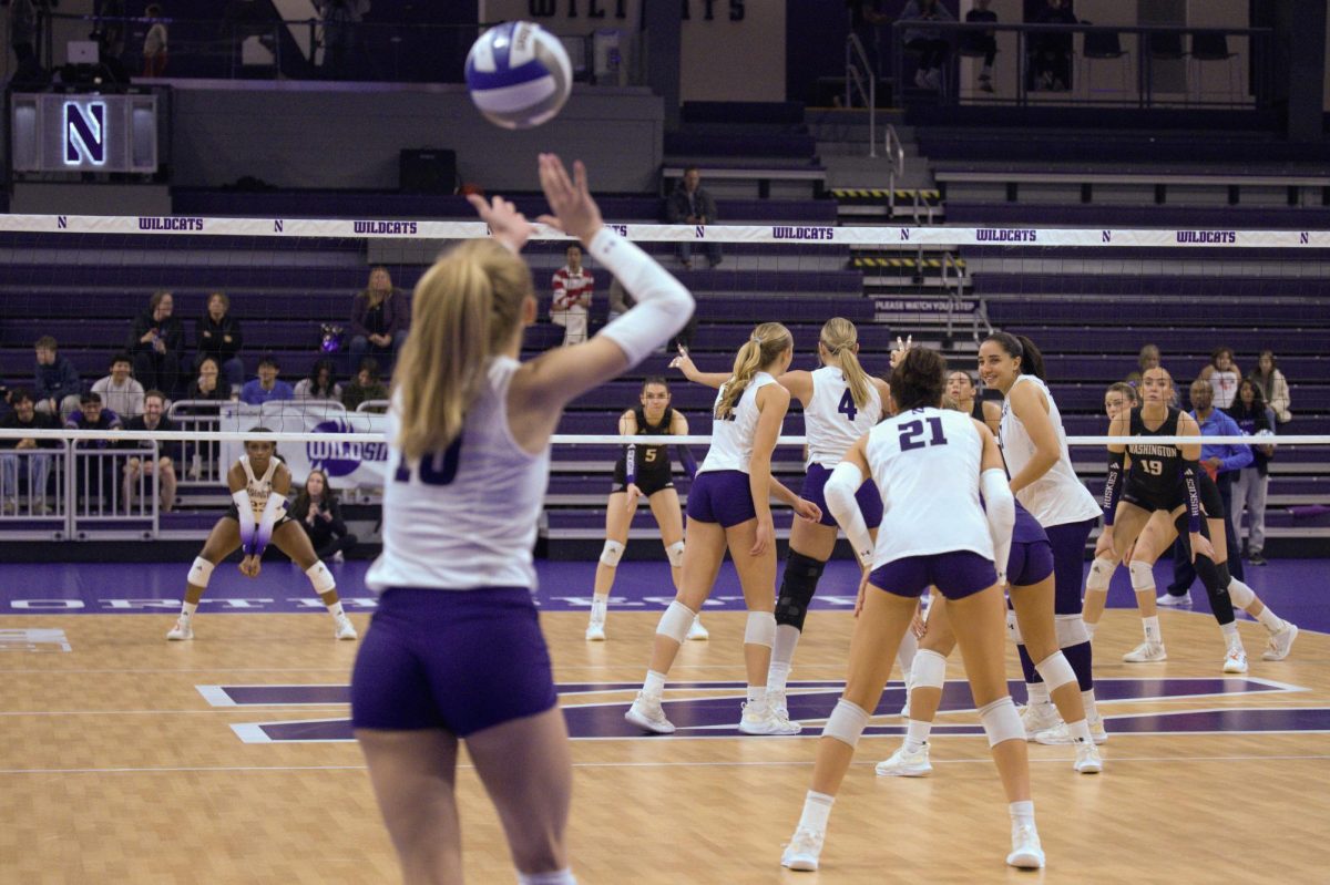 Lauren Carter serves the ball as other players prepare for the round.