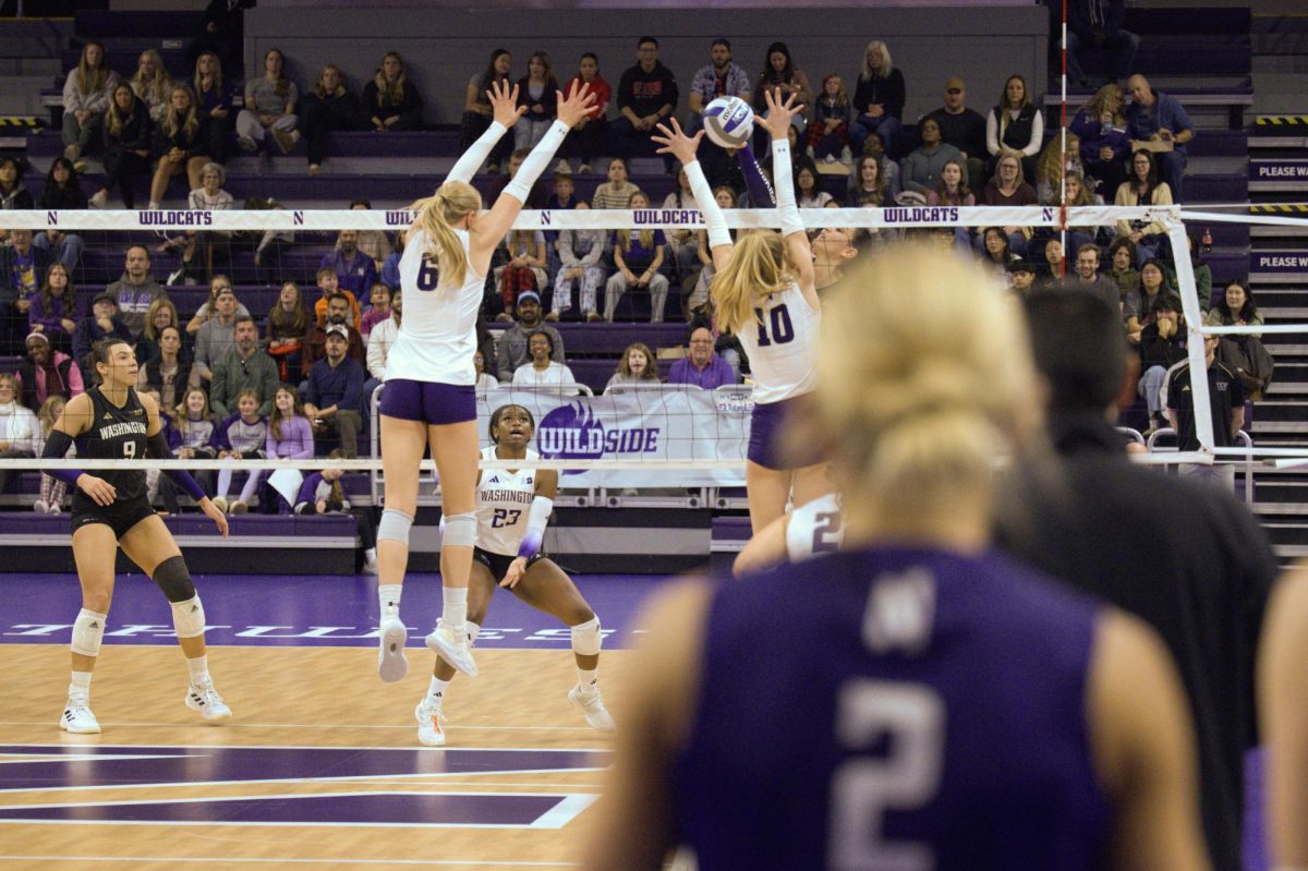 Drew Wright watches from the sidelines as teammates Carter and Bella Simkus block a hit from Washington