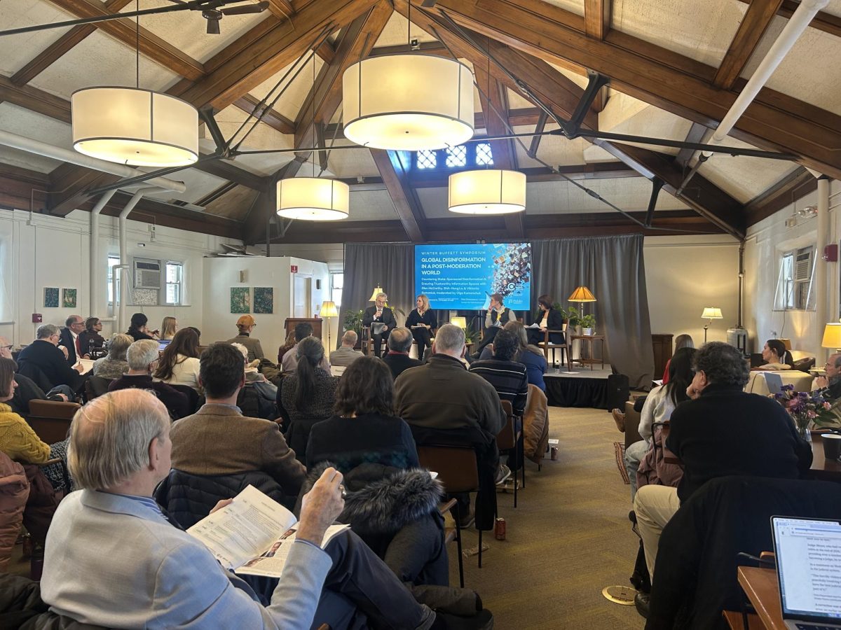 A room of attendees watching panelists speak on a stage.
