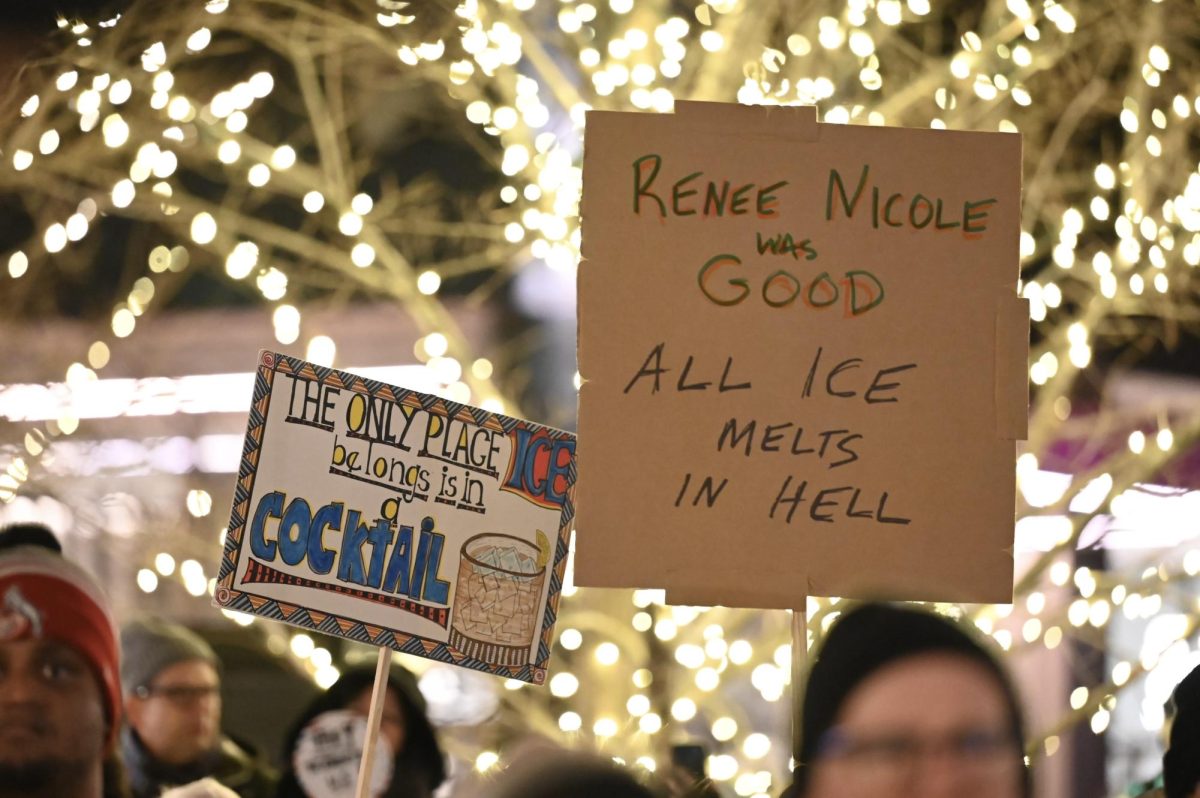 Attendees hold two handmade signs.