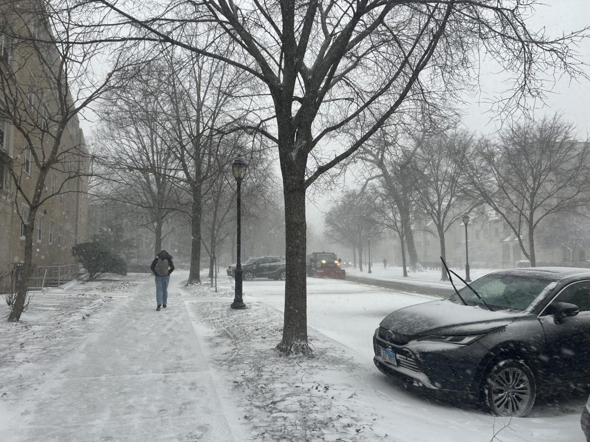 A student walks along a snow-covered sidewalk on Northwestern’s campus during a winter storm.