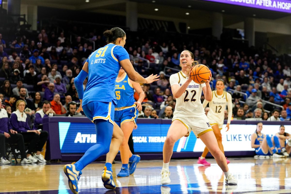 A basketball player in a white jersey faces up to the basket.