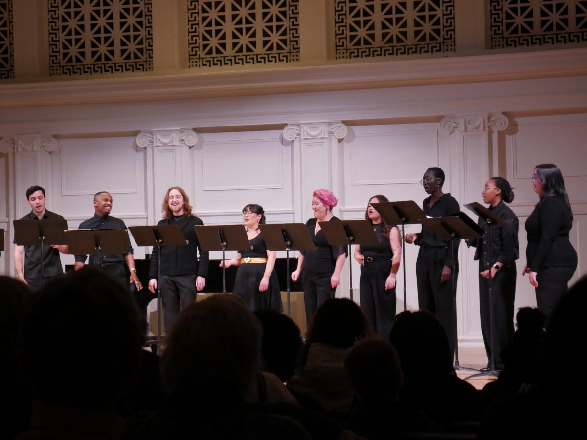 Members of a choir sing on an illuminated stage.