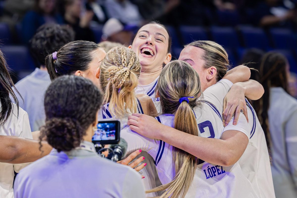 A group of Northwestern players hug and shout in excitement after securing the win.