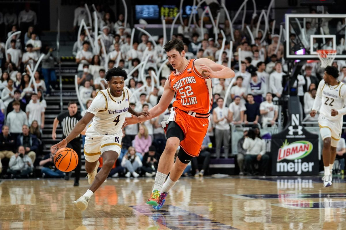A basketball player dribbles down the court, attempting to avoid an opposing player trying to steal the ball.