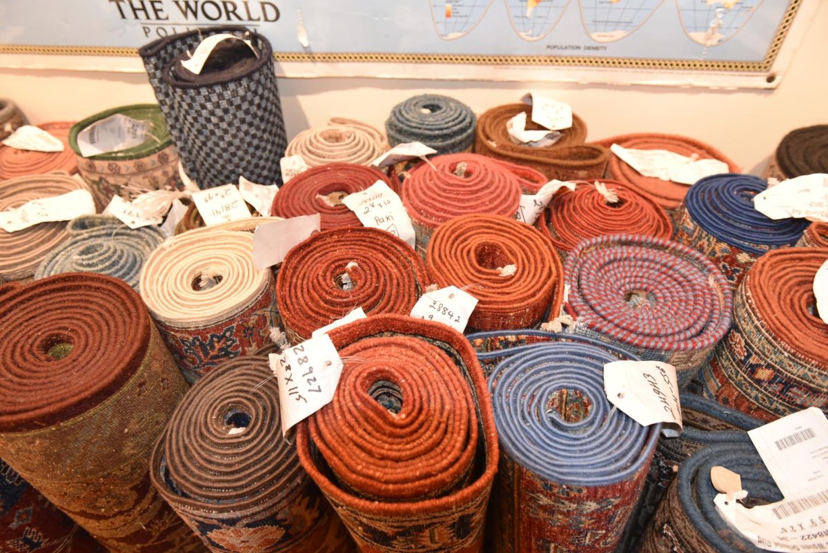 Rolled up rugs in front of a poster.