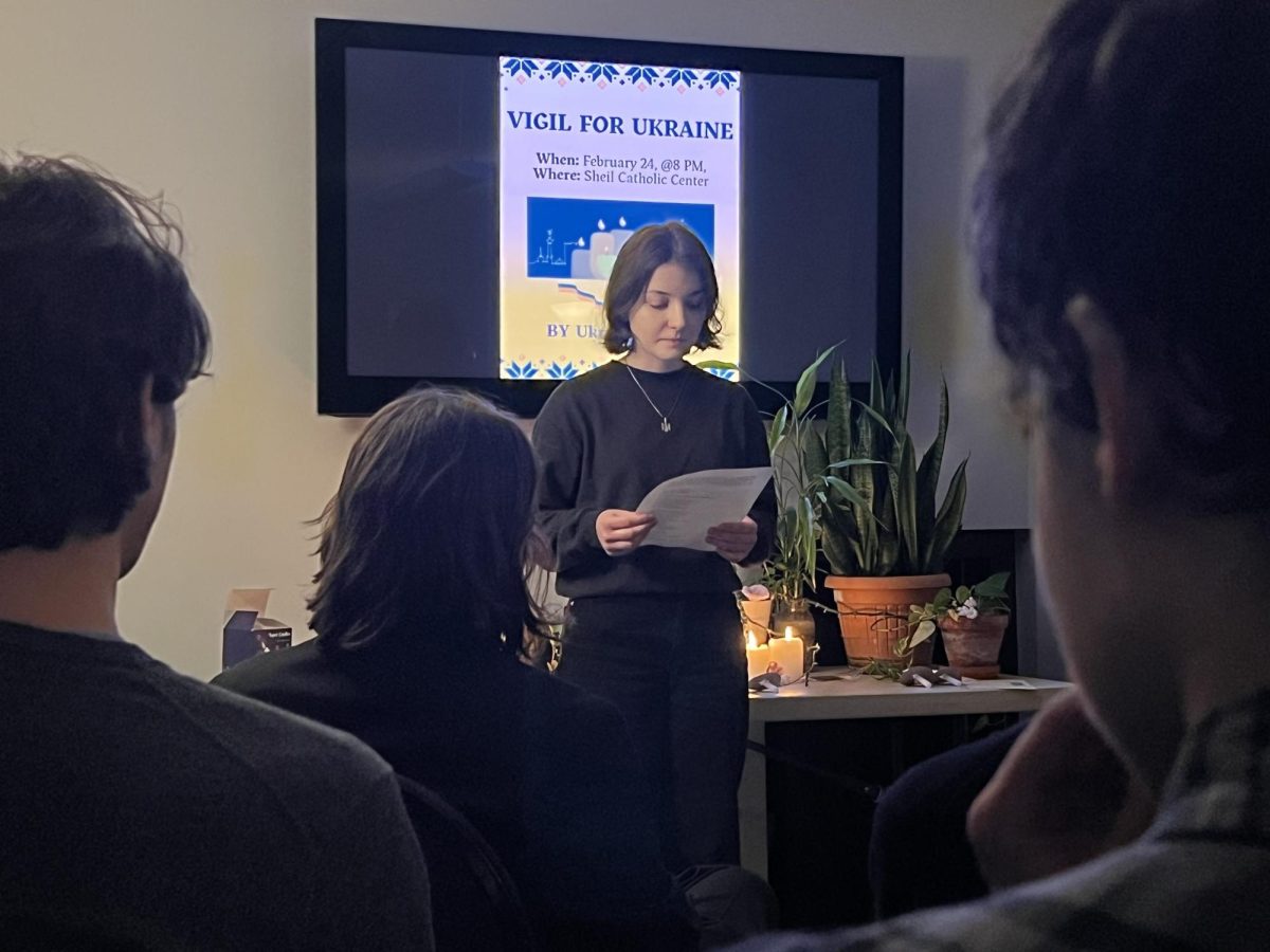 A person standing in front of a television reads a sheet of paper.