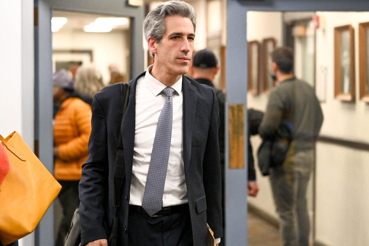 A person wearing a suit walks into a room.
