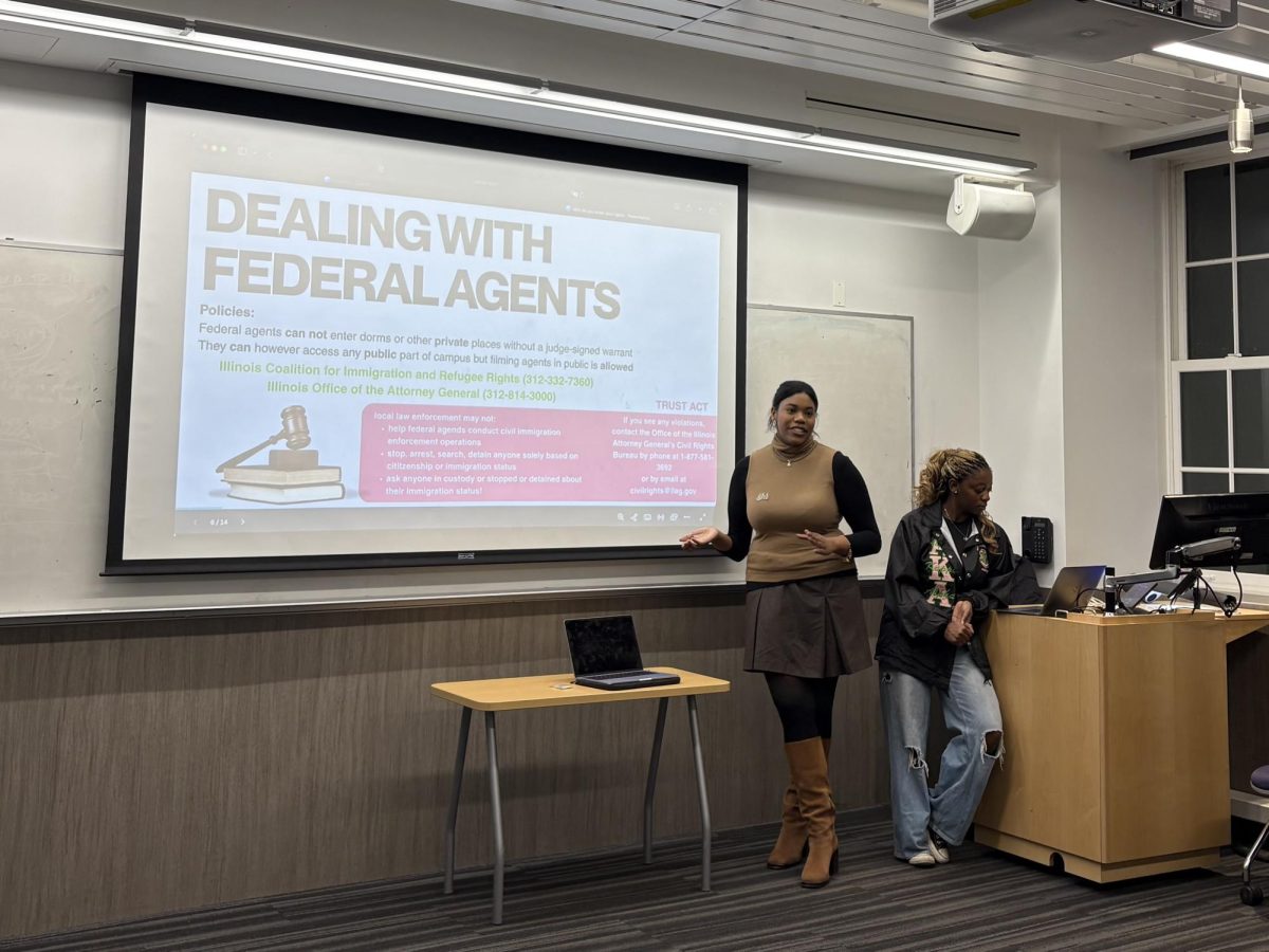 Two people stand to the right of a presentation that describes how to deal with federal agents.
