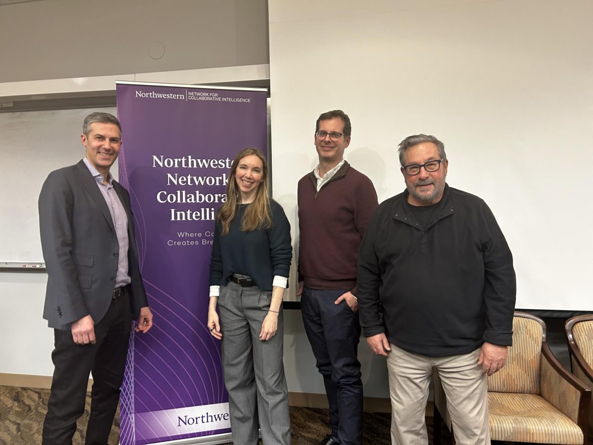Four people standing in front of a Northwestern Network for Collaboration Intelligence banner.