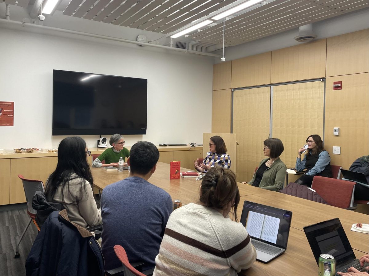 Mariana Dimópulos sits at a table with students and professors discussing her book, “Speaking in Tongues,” which is placed in the middle of the table.