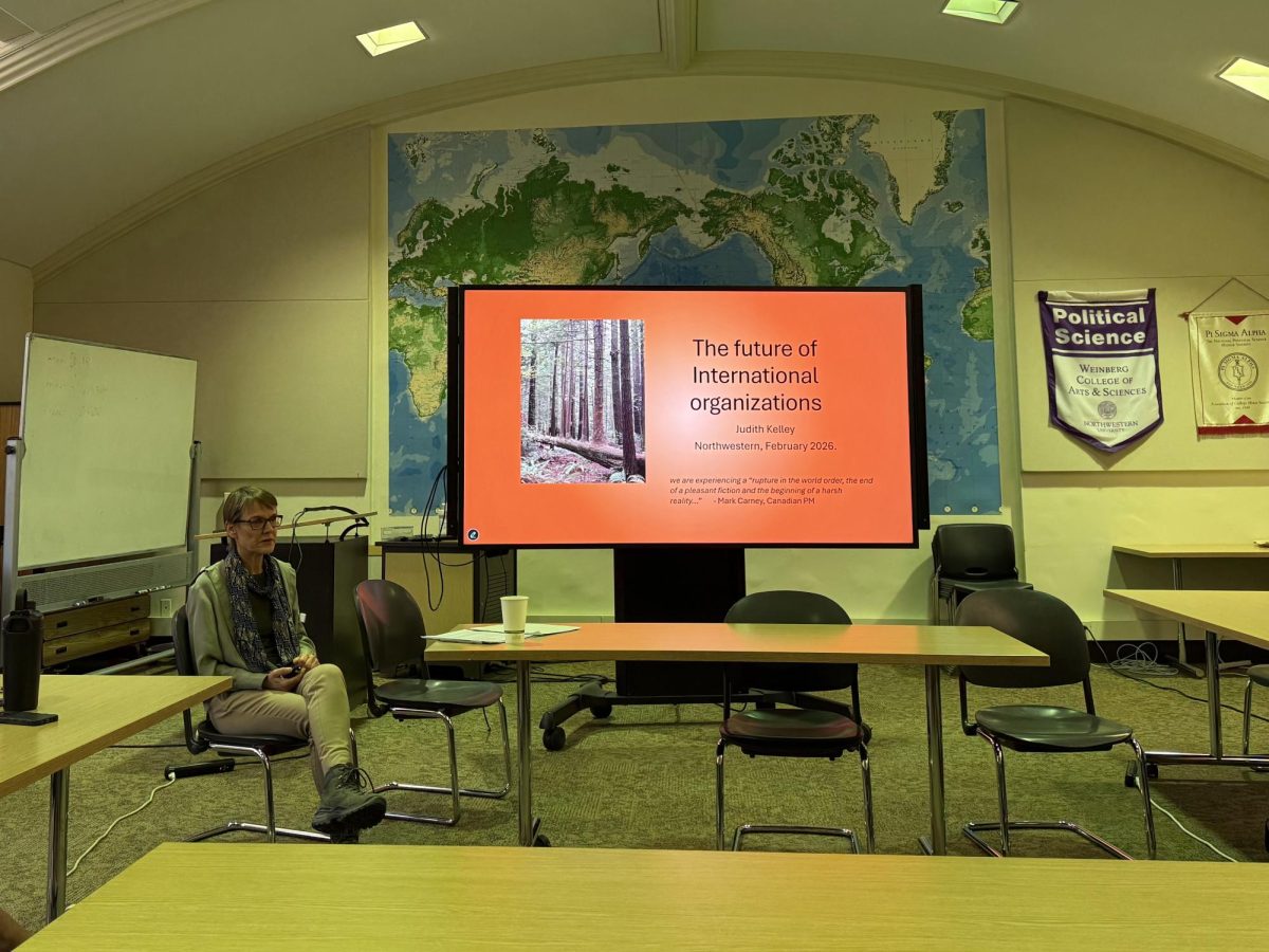 A person sits in front of a slideshow presentation being projected on a large screen.