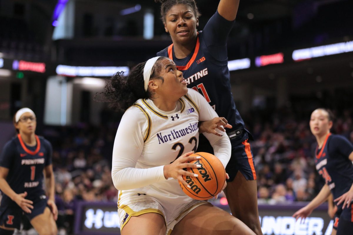 A person in a white jersey holds a basketball and looks up.