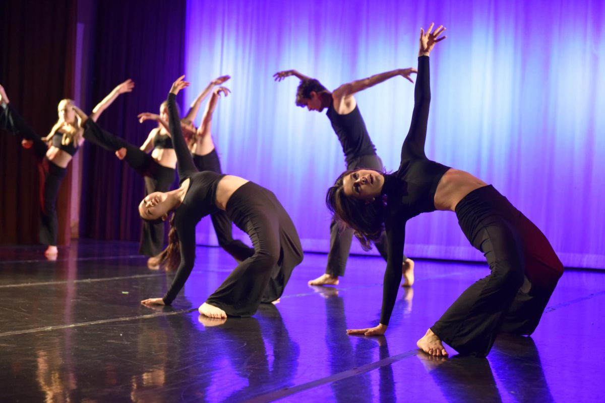 Dancers in all black bend over backwards.
