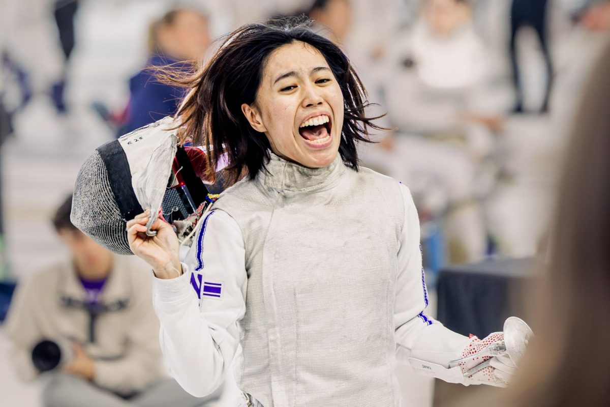 A fencer cries out in celebration after tearing off their mask.
