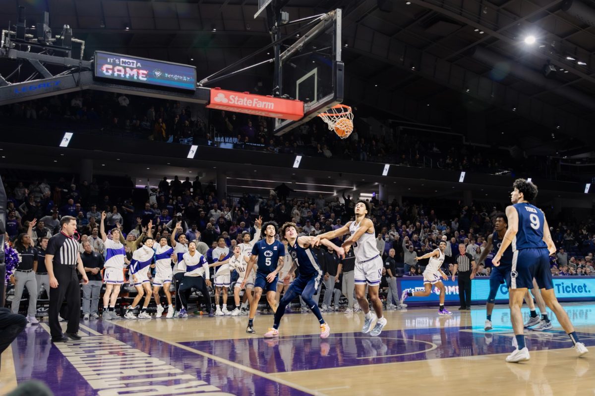 Two players wait under the hoop for a rebound, while players on the bench celebrate in the background.