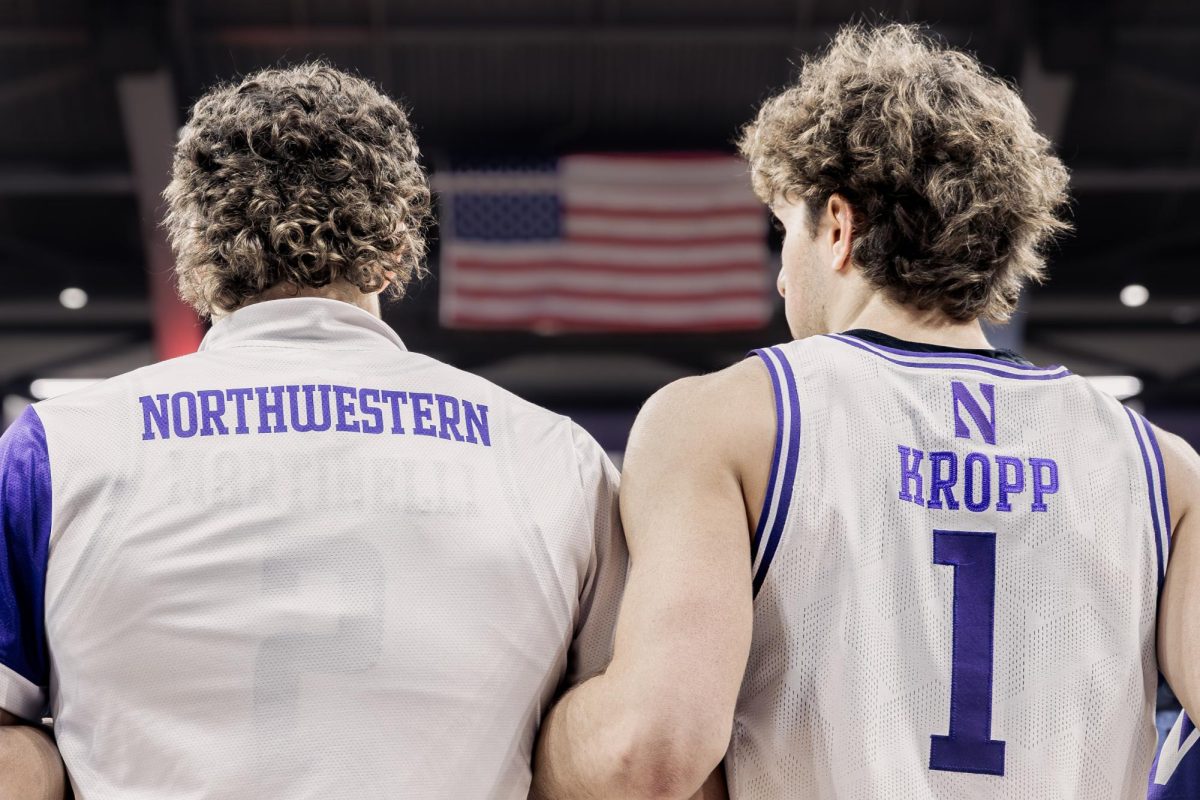 Two players stand side-by-side with an American Flag framed between their shoulders.