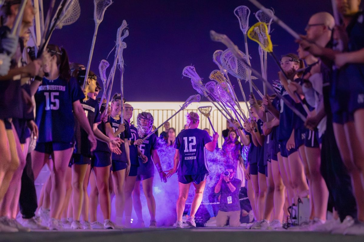 Graduate student attacker Olivia Adamson runs through the tunnel during pregame introductions.