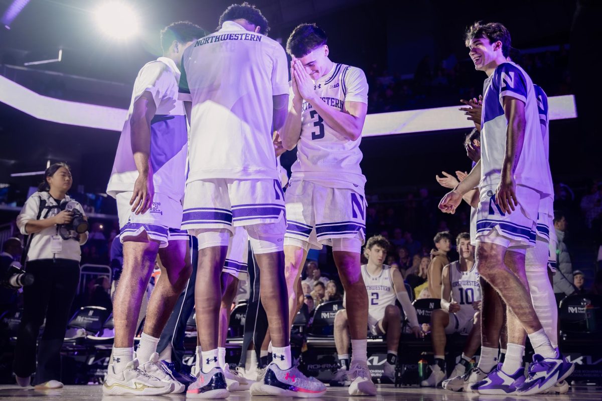 Two players stand face to face with their hands pressed together and heads down.