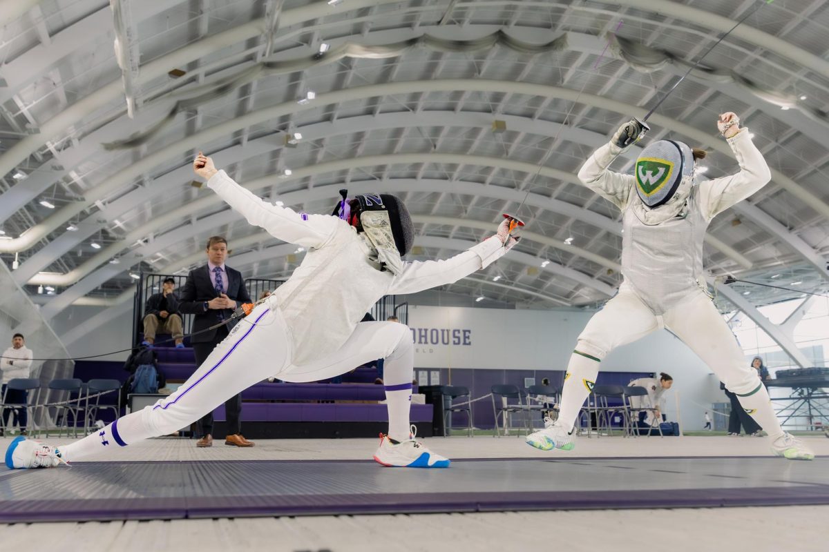 A Northwestern fencer lunges towards an opponent who’s pulling away.