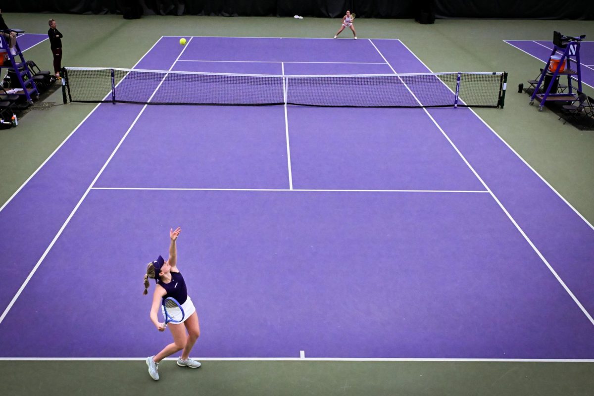 Two tennis players play on a purple court.