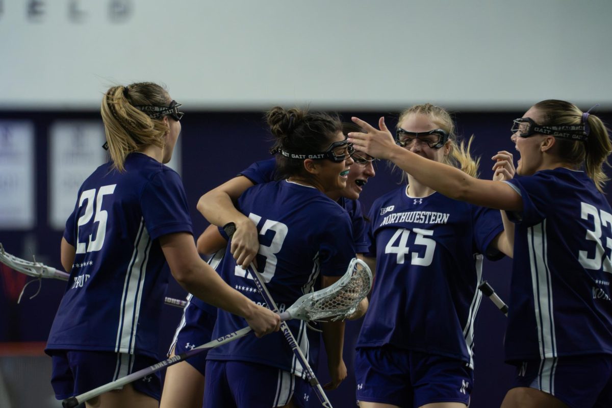 Players in purple jerseys huddle together in celebration.